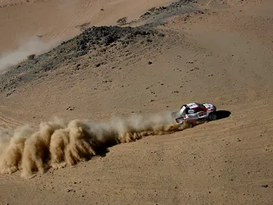 Pembalap Toyota Gazoo Racing Frenando Alonso dan Marc Coma bersaing pada stage pertama Reli Dakar 2020 antara Jeddah dan Al Wajh, Arab Saudi, Minggu (5/1/2020). Alonso mencetak sejarah sebagai juara dunia Formula 1 (F1) pertama yang berlaga di ajang Reli Dakar. (FRANCK FIFE/AFP)