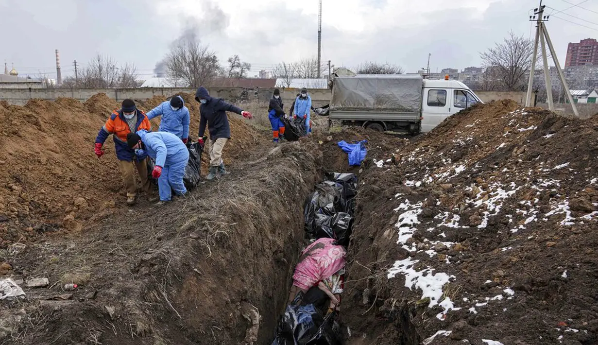 Sejumlah jenazah dimasukkan ke dalam kuburan massal di pinggiran Mariupol, Ukraina, 9 Maret 2022. Warga tidak dapat menguburkan orang mati di antara mereka karena serangan berat oleh pasukan Rusia. (AP Photo/Evgeniy Maloletka)