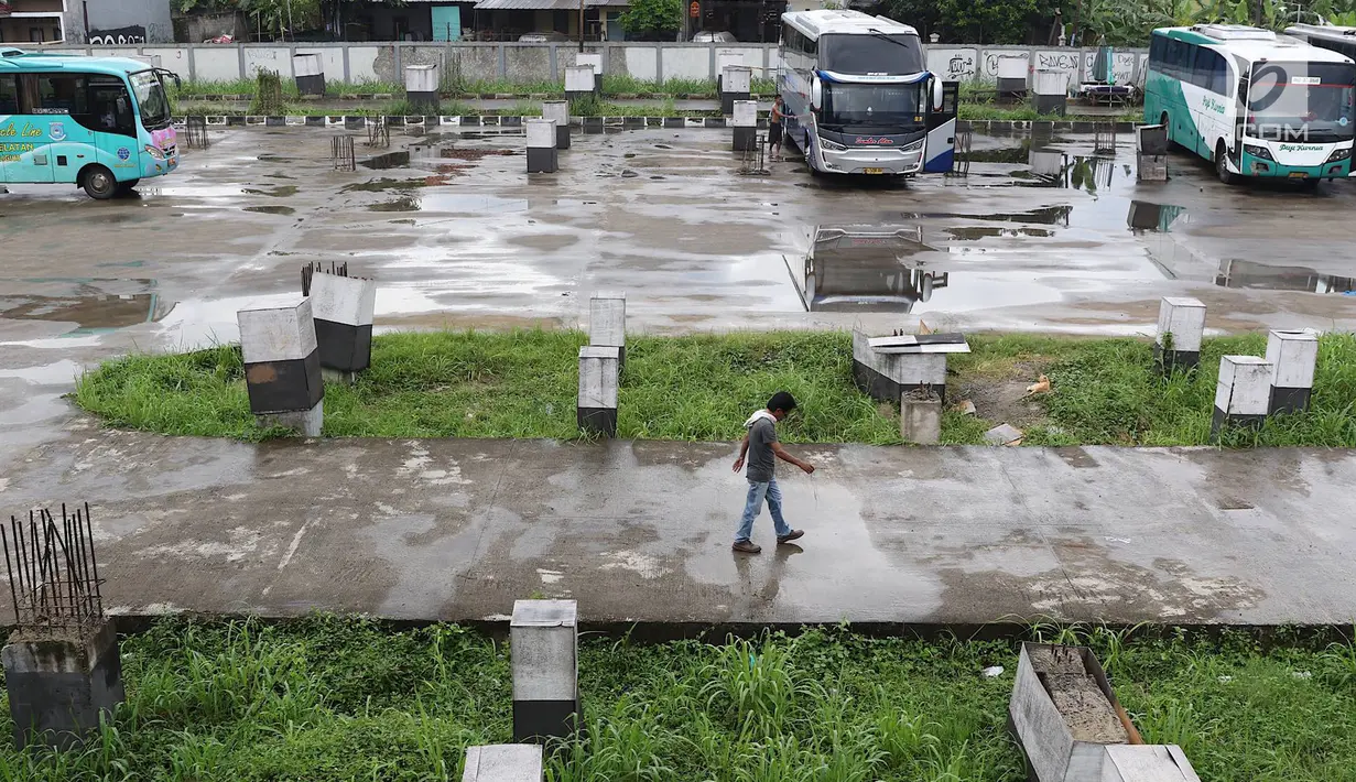 Seorang pria berjalan di Teminal Pondok Cabe, Jakarta, Senin (18/3). Aktivitas di Terminal Pondok Cabe pada Februari 2019 menunjukkan terdapat 646 Bus Angkutan Kota Antar Provinsi dengan 1171 keberangkatan penumpang. (Liputan6.com/Immanuel Antonius)