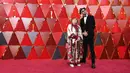 Agnes Varda dan JR menghadiri malam penghargaan Piala Oscar 2018 atau Academy Award ke-90 di Los Angeles, Minggu (4/3). Agnes Varda memilih mengenakan sepatu warna perak ketimbang hak tinggi di karpet merah. (Neilson Barnard/GETTY IMAGES/AFP)