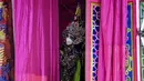 Seorang pemain Opera tradisional Tiongkok dari rombongan Sai Yong Hong melihat keluar dari belakang panggung selama perayaan Tahun Baru Imlek yang akan datang, di gudang Lhong 1919 di Bangkok (19/1/2022). (AFP/Lillian Suwanrumpha)