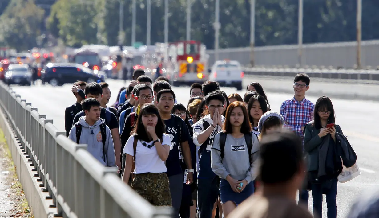 Sejumlah orang berjalan menjauh usai kecelakaan antara bus carter mahasiswa dengan kendaraan wisata amfibi di sebuah jembatan di Seattle, AS, Kamis (25/9). Tiga orang mahasiswa Indonesia lainnya yang mengalami luka-luka. (REUTERS/Jason Redmond)