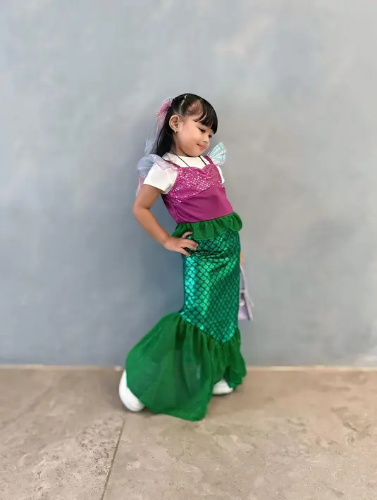 Berpose dengan tolak pinggang, rambut Ameena Atta ditata dengan halt ponytail berpitan dan poni depan [@aurel.hermansyah]