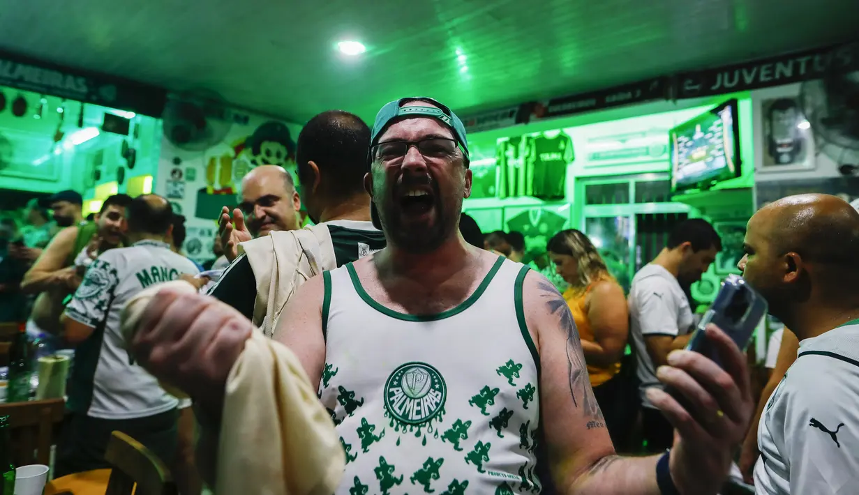 Suporter Palmeiras merayakan kemenangan timnya saat menonton siaran langsung pertandingan kejuaraan Copa Libertadores, di Sao Paulo, Brasil, Sabtu (27/11/2021). Palmeiras kampiun Copa Libertadores 2021 usai mengalahkan Flamengo 2-1 di Stadion Centenario, Uruguay.  (AP Photo/Marcelo Chello)