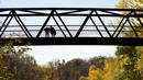 Orang-orang memandangi Sungai Kredit di sebuah jembatan, di antara warna-warni musim gugur di Mississauga, Ontario, pada Kamis, 27 Oktober 2022. (Nathan Denette/The Canadian Press via AP)