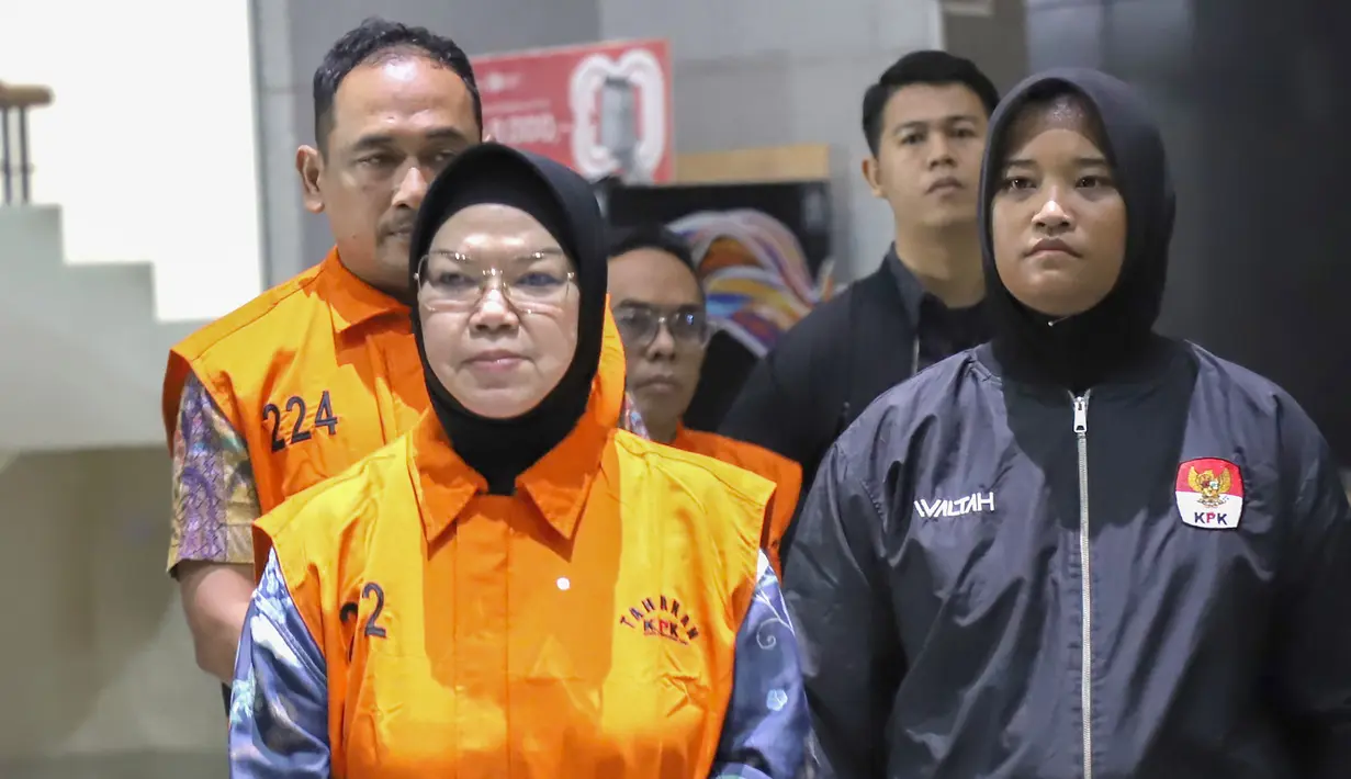 Bupati Sukoharjo Etik Suryani mengenakan rompi tahanan  dibawa menuju mobil tahanan usai menjalani pemeriksaan di Gedung Merah Putih KPK, Jakarta, Sabtu (11/7/2026). (KLY/Arie Basuki)