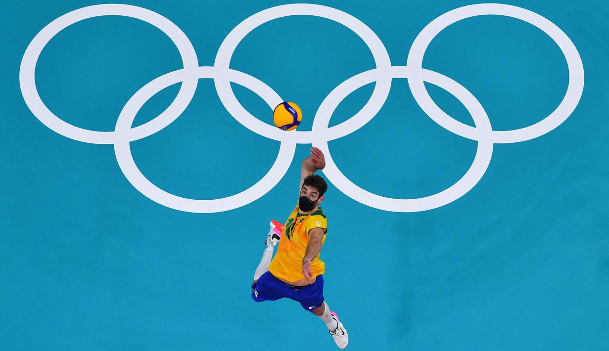 Pevoli Brasil, Lucas Saatkamp melakukan servis dalam pertandingan bola voli babak penyisihan grup B putra Olimpiade Tokyo 2020 antara Brasil dan AS di Ariake Arena pada 30 Juli 2021. Lucas Saatkamp menjadi sorotan di Olimpiade karena selalu menggunakan masker saat bertanding. (Antonin THUILLIER/AFP)