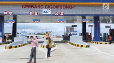 Beberapa warga berfoto berlatar gerbang tol Cigombong I di Cigombong, Kab Bogor, Jawa Barat, usai diresmikan, Sabtu (1/12). Ruas panjang tol Ciawi-Sukabumi Seksi I Ciawi-Cigombong sejauh 15,3 kilometer. (Liputan6.com/Helmi Fithriansyah)