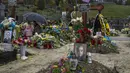 Tetiana Rurak (25) mengunjungi makam suaminya yang merupakan seorang tentara, Volodymyr Rurak, bersama putrinya yang berusia satu setengah tahun setelah suaminya itu terbunuh dalam perang dengan Rusia di pemakaman Lychakiv, Lviv, Ukraina, Selasa (5/4/2022). (AP Photo/Nariman El-Mofty)