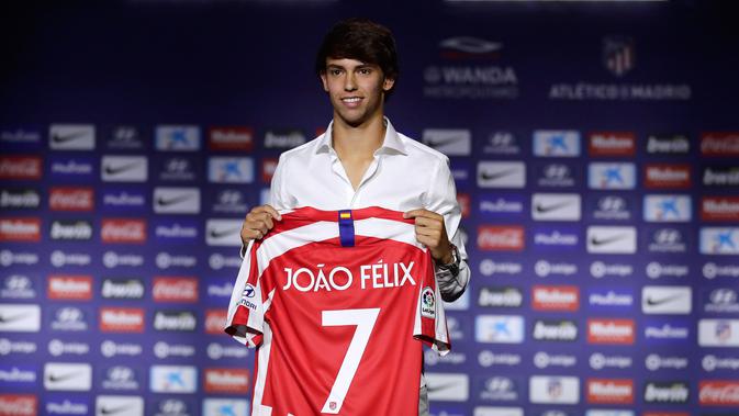 Gelandang Atletico Madrid, Joao Felix tersenyum saat berpose dengan jersey klub barunya selama perkenalan dirinya di Stadion Wanda Metropolitano, Madrid (8/7/2019). Pemain Portugal ini resmi diboyong Atletico seharga 126 juta euro dengan kontrak selama tujuh tahun. (AP Photo/Manu Fernandez)