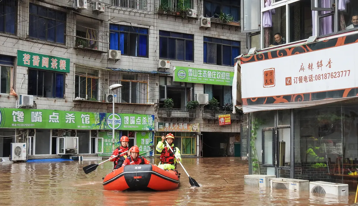 Tim penyelamat mengevakuasi penduduk di daerah banjir setelah hujan deras di daerah Quxian, kota Dazhou, di provinsi Sichuan barat laut China (6/9/2021). (AFP/STR)