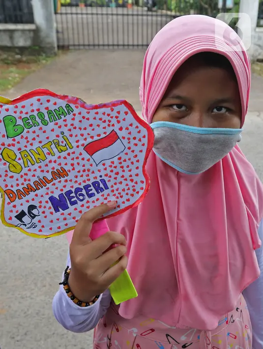 Seorang anak pengajian melakukan pawai di Jalan Raya Tapos, Depok, Jawa Barat, Kamis (22/10/2020). Pengajian Kampung Tapos menggelar pawai menyambut Hari Santri Nasional 2020 yang diperingati setiap tanggal 22 Oktober. (Liputan6.com/Herman Zakharia)