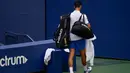 Petenis Serbia, Novak Djokovic meninggalkan lapangan usai gagal menghadapi Pablo Carreno Busta dari Spanyol pada putaran keempat US Open 2020, di Flushing Meadows, (6/9/2020). Djokovic didiskualifikasi dari AS Terbuka 2020 setelah tidak sengaja memukul hakim garis dengan bola. (AP Photo/Seth Wenig)