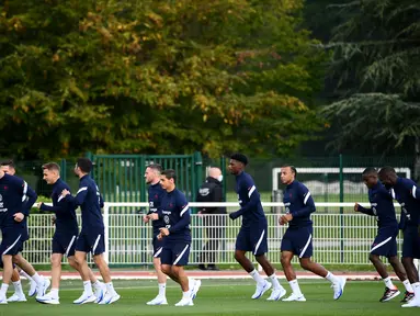 Para pemain Prancis melakukan pemanasan saat mengikuti sesi latihan tim di Clairefontaine-en-Yvelines (4/10/2021). Prancis akan bertanding melawan Belgia pada semifinal UEFA Nations League di Allianz Stadium. (AFP/Franck Fife)