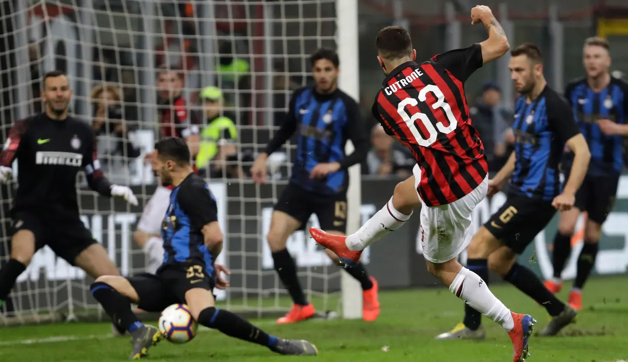 Pemain AC Milan Patrick Cutrone (tengah) menendang bola ke arah gawang saat menghadapi Inter Milan pada laga pekan 28 Liga Italia Serie A di Stadion San Siro, Milan, Minggu (17/3). Inter menggeser Milan dari posisi tiga klasemen. (AP Photo/Luca Bruno)