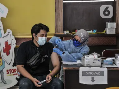 Warga menerima vaksinasi Covid-19 dosis kedua di Gelanggang Remaja Pulogadung, Rawamangun, Jakarta, Kamis (18/11/2021). Kementerian Kesehatan mencatat, capaian vaksinasi dosis kedua di Indonesia hingga Kamis (18/11) pukul 12.00 telah mencapai 86.335.923 orang. (merdeka.com/Iqbal S. Nugroho)