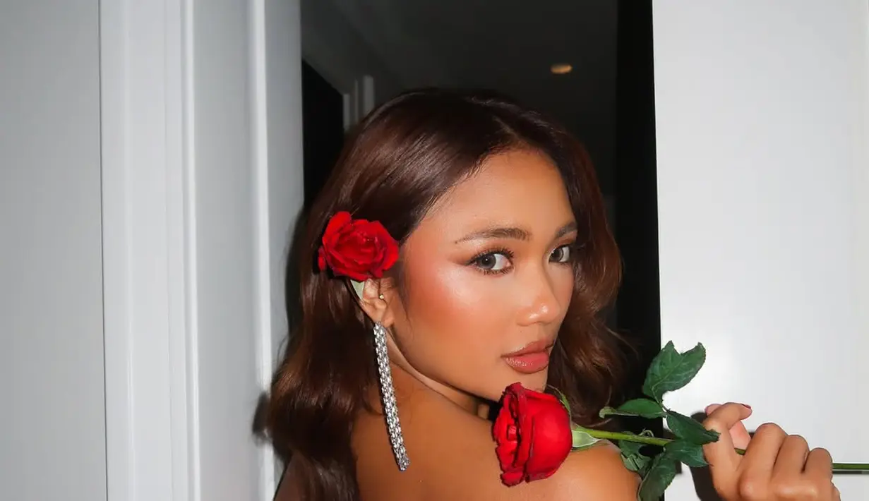 Rambut panjangnya ditata sided wavy berhiaskan mawar yang perlihatkan anting berlian panjang [@lalamarionmj]