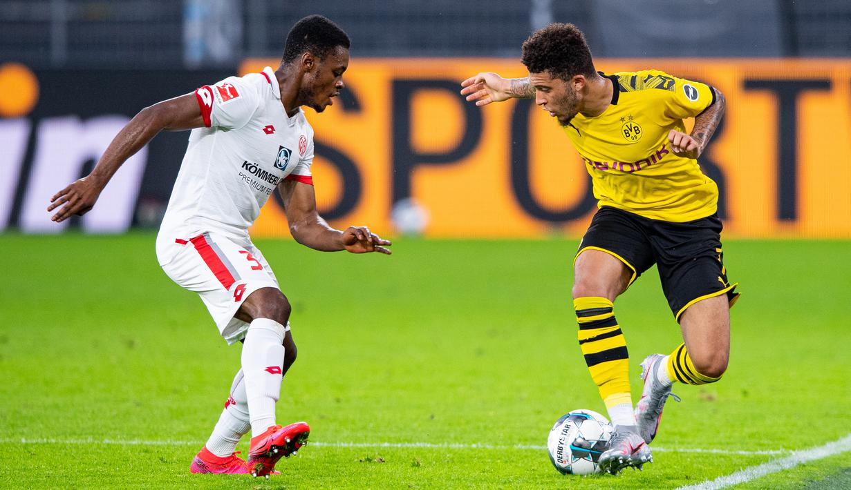Gelandang Borussia Dortmund, Jadon Sancho, berebut bola dengan gelandang Mainz, Ridle Baku, pada laga lanjutan Bundesliga di Signal Iduna Park, Dortmund, Kamis (18/6/2020) dini hari WIB. Borussia Dortmund menyerah 0-2 atas Mainz. (AFP/Guido Kirchner/pool)