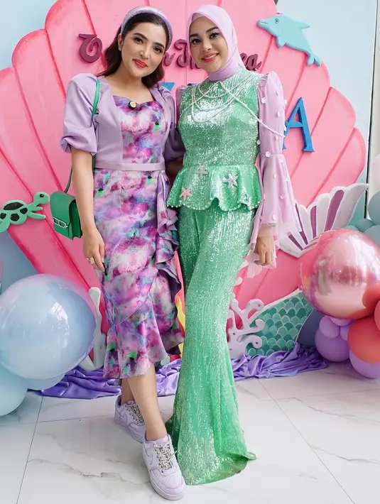 Kombinasi bahan satin dan detail ruffle pada gaun memberikan kesan feminin yang kuat. Tak hanya itu, ia juga melengkapi tampilannya dengan aksesori berupa headband ungu mengilap yang membuatnya terlihat seperti karakter Barbie. [@ashanty_ash].