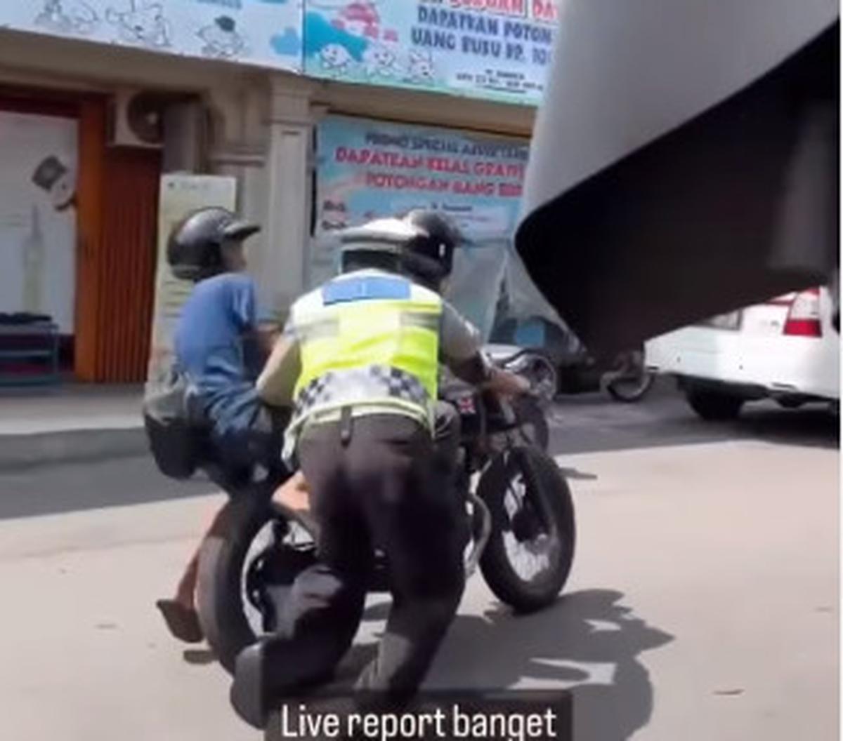 Lantaran kendaraan terus melaju, petugas berseragam itu nampak terseret sejauh 5 meter dari lokasi. <br><br>"Live report banget. Sabar pak polisi, tetap semangat @satlantasjogja," demikian dikutip dari keterangan video.
