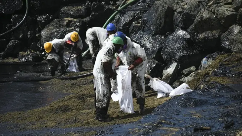 Para pekerja membersihkan tumpahan minyak di Pantai Rockly Bay di Scarborough, Trinidad dan Tobago, pada 10 Februari 2024.
