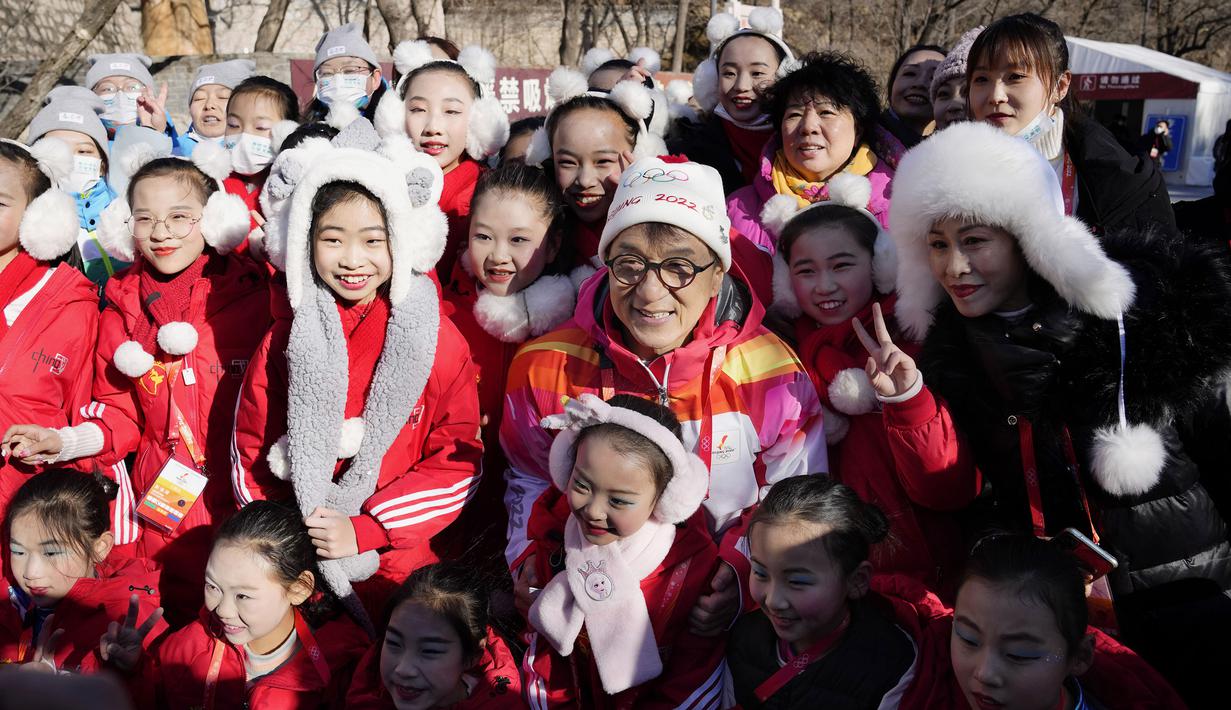 Selebriti Hong Kong Jackie Chan berfoto bersama anak-anak setelah mengikuti estafet obor Olimpiade Musim Dingin 2022 di Tembok Besar Badaling di pinggiran Beijing, Cina, Kamis, 3 Februari 2022. (AP/Ng Han Guan)
