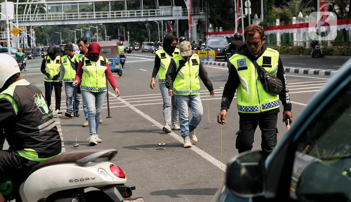 Relawan dari komunitas sapu bersih (saber) ranjau paku menyisir rute yang akan dilewati Pemimpin Gereja Katolik Dunia Paus Fransiskus, Rabu (4/9/2024). (Liputan6.com/Angga Yuniar)