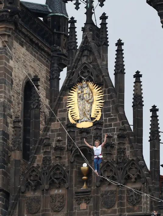 Atlet wanita menyeimbangkan tubuhnya saat berjalan di atas tali yang membentang di Old Town Square, Praha, Republik Ceko, (25/9). Pertunjukan tersebut merupakan bagian kampanye dukungan orang-orang yang hidup dengan diabetes. (AP Photo/Petr David Josek)