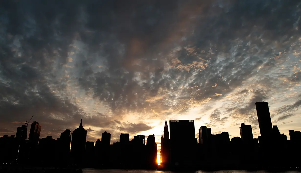 Pemandangan Manhattanhenge di New York, AS, Senin (11/7). Manhattanhenge adalah sebutan untuk sunset sempurna di New York di mana matahari berada tepat di antara 2 gedung yang terbelah dengan jalan. (Drew Angerer / Getty Images / AFP)