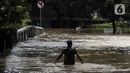 Warga berjalan menyusuri banjir di kawasan Kemang, Jakarta, Sabtu (20/2/2021). Curah hujan yang tinggi menyebabkan kawasan tersebut terendam banjir setinggi orang dewasa. (Liputan6.com/Johan Tallo)