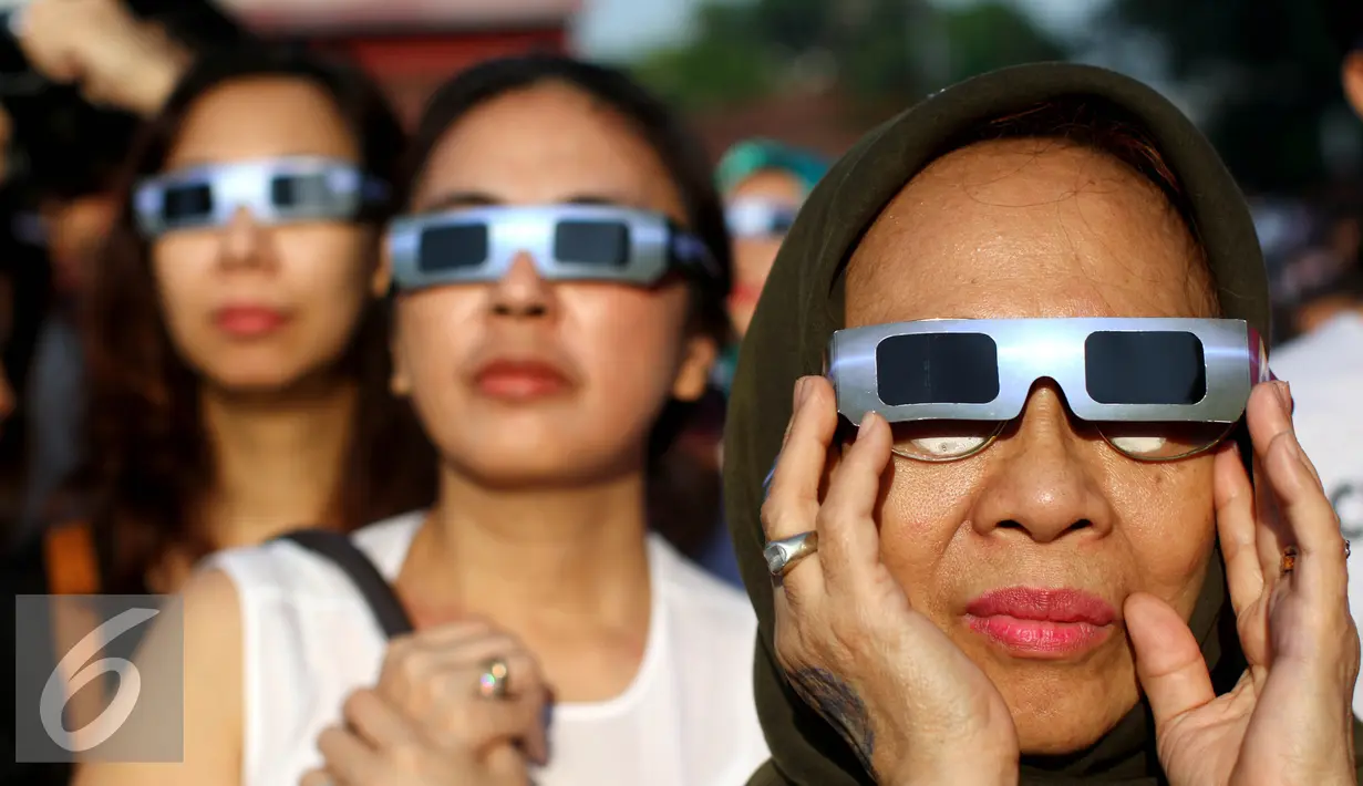 Warga mengunakan kacamata khusus menyaksikan proses Gerhana Matahari Total (GMT) 2016 di halaman Taman Ismail Marzuki (TIM), Jakarta, Rabu (9/3). Di Jakarta, gerhana matahari terjadi sebesar 88,76 persen selama sekitar 2. (Liputan6.com/Fery Pradolo)
