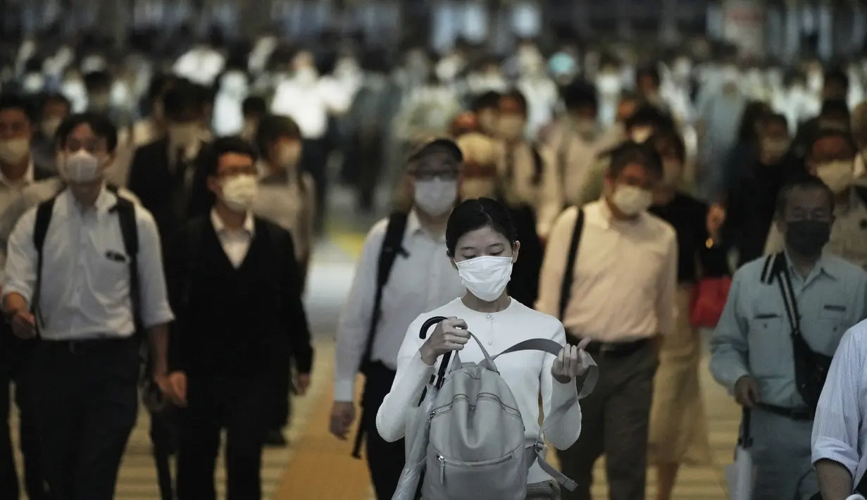 Komuter yang mengenakan masker berjalan di lorong selama jam sibuk di Stasiun Shinagawa, Tokyo, Jumat (1/10/2021). Pemerintah Jepang mencabut keadaan darurat di semua wilayah pada 1 Oktober 2021. (AP Photo/Eugene Hoshiko)