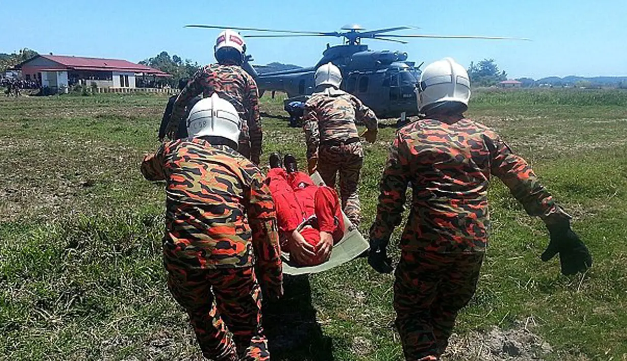 Personel AU Malaysia terlihat membawa salah satu awak pesawat tim aerobatik TNI AU Jupiter menggunakan helikopter menuju rumah sakit, Minggu (14/3/2015). (Dailymail)