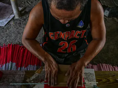 Pekerja menyelesaikan pembuatan petasan di sebuah pabrik di Bocaue, Bulacan, Filipina, Jumat (27/12/2019). Petasan-petasan tersebut akan dijual untuk perayaan Tahun Baru 2020. (Maria TAN/AFP)