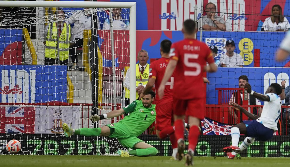Gelandang Timnas Inggris, Bukayo Saka (kanan) mencetak gol kelima Inggris ke gawang Makedonia Utara pada laga Grup C kualifikasi Euro 2024 antara Timnas Inggris menghadapi Makedonia Utara di Old Trafford, Manchester (19/6/2023). (AP Photo/Dave Thompson)