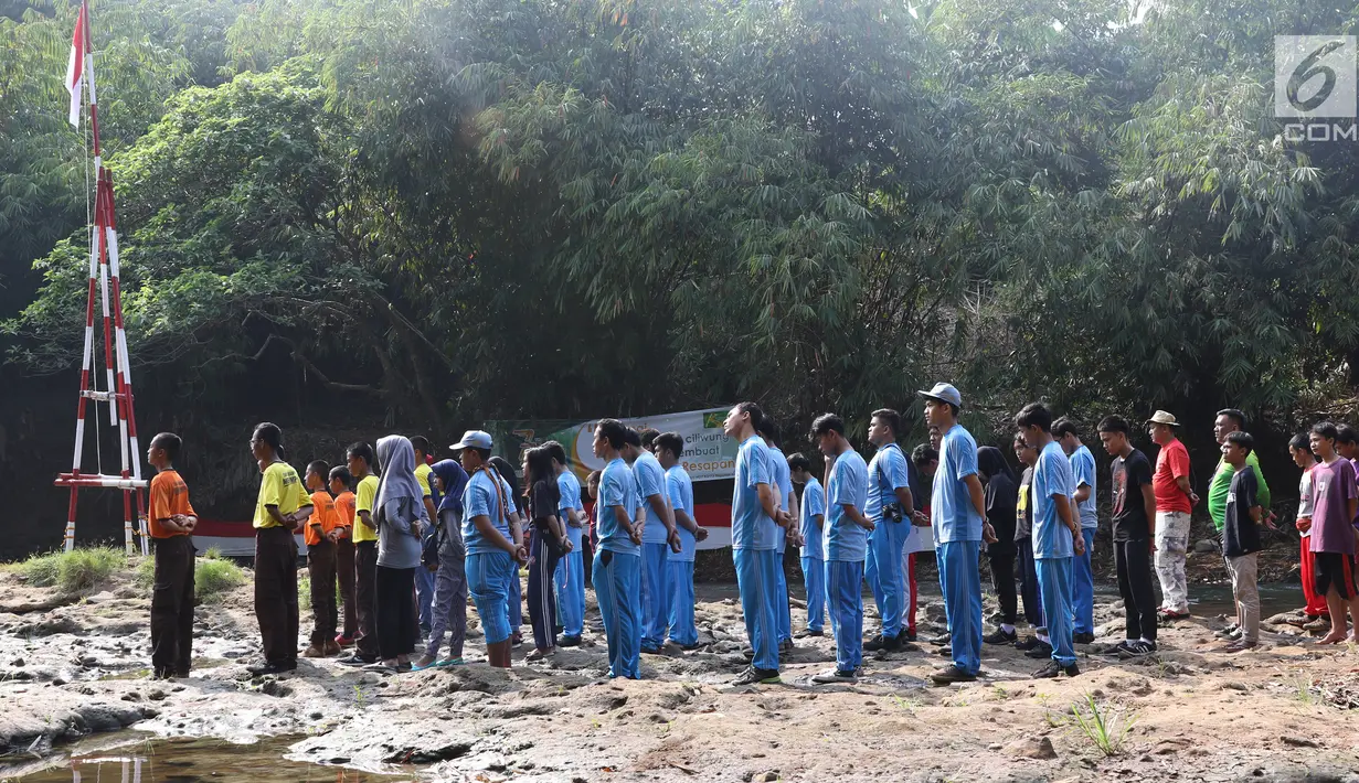 Komunitas Ciliwung bersama pelajar dan warga mengikuti upacara bendera di Sungai Ciliwung, Depok, Jumat (17/8). Upacara HUT ke-73 RI tersebut bertujuan mengedukasi masyarakat untuk menjaga kelestarian Sungai Ciliwung. (Liputan6.com/Immanuel Antonius)