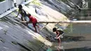 Anak-anak bermain di sungai di Jakarta, Sabtu (7/4). Gubernur DKI Jakarta Anies Baswedan memastikan akan tetap membangun Ruang Terbuka Hijau (RTH). RTH yang dimaksud yakni membangun Taman Maju Bersama dan Taman Pintar. (Liputan6.com/Angga Yuniar)