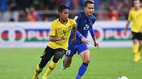 Pemain Timnas Malaysia, Syahmi Safari (kiri), saat melawan Timnas Thailand di leg kedua semifinal Piala AFF 2018 di Stadion Rajamangala, Bangkok (5/12/2018).  (AFP/Lillian Suwanrumpha)