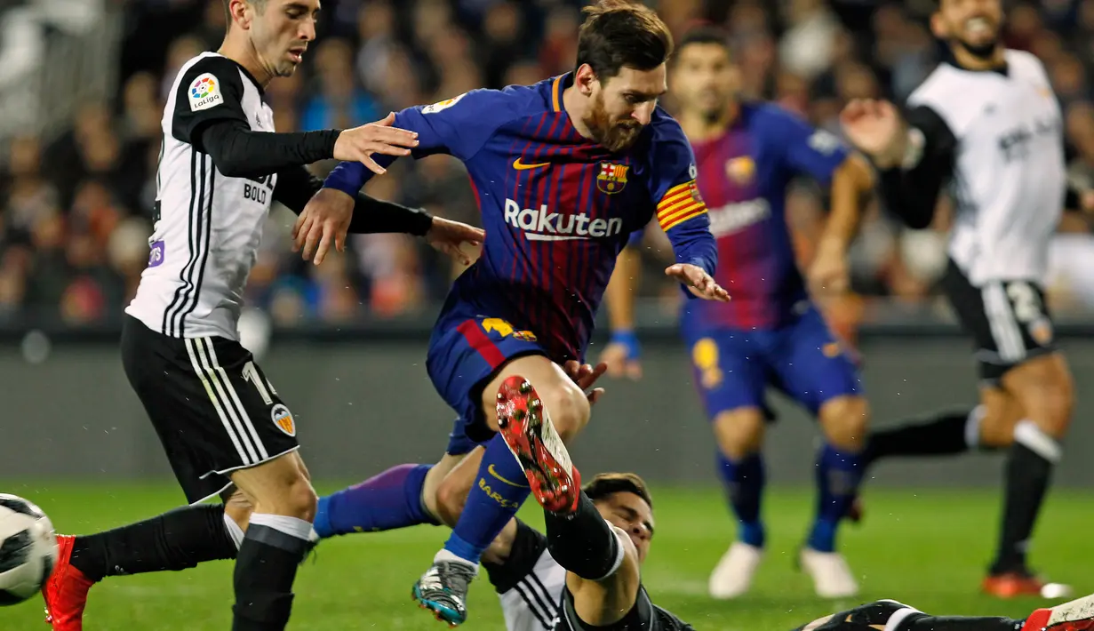 Striker Barcelona Lionel Messi dihadang dua pemain Valencia saat pertandingan Copa del Rey di stadion Mestalla di Valencia (8/2). Dengan hasil kemenangannya, Barcelona sukses memastikan tiket ke final Copa del Rey. (AP Photo/Alberto Saiz)
