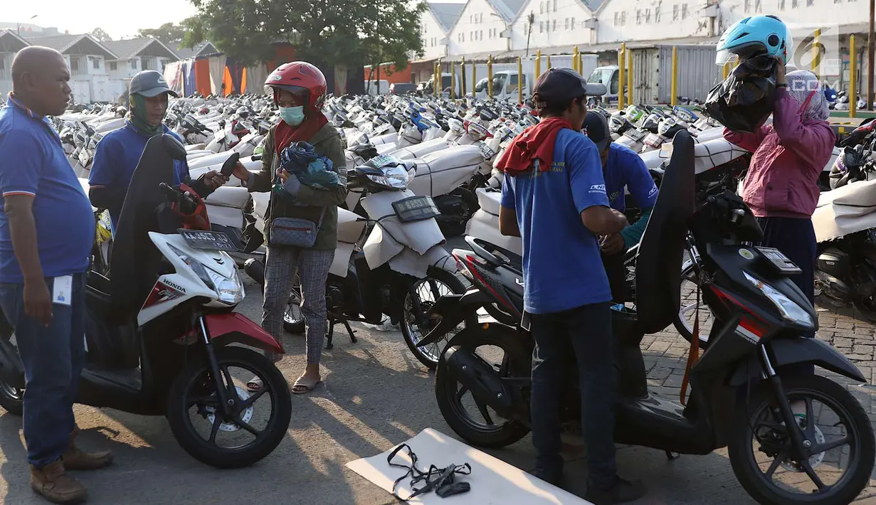 Petugas mengemas sepeda motor untuk diangkut dengan kereta api Stasiun Kampung Bandan, Jakarta, Senin (11/6). Program mudik gratis ini digagas Kemenhub tersebut melayani pengiriman ke beberapa daerah di Pulau Jawa. (Liputan6.com/Immanuel Antonius)