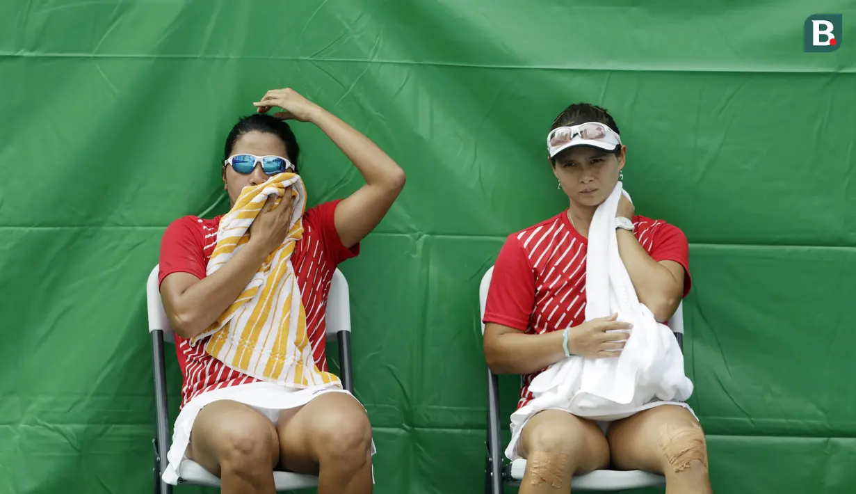 Ganda putri Indonesia, Beatrice Gumulya / Jessie Rompies, istirahat saat melawan wakil Thailand pada laga final SEA Games 2019 di Tennis Court Rizal Memorial Sports Complex, Manila Sabtu (7/12). Indonesia menang dengan skor 6-3 dan 6-3. (Bola.com/ M Iqbal Ichsan)