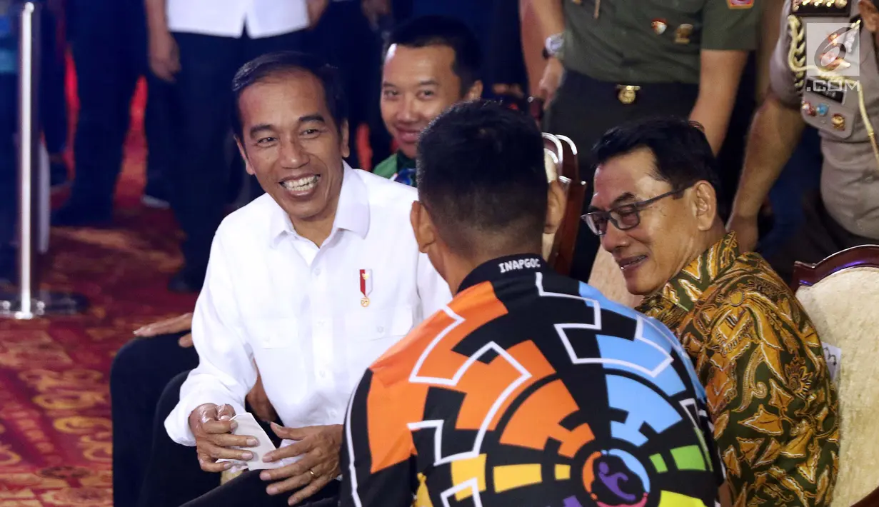 Presiden RI, Joko Widodo (tengah) berbincang bersama Ketua INAPGOC, Raja Sapta Oktohari jelang laga atlet para powerlifting Indonesia di kelas Womens Up 73 dan 79kg Asian Para Games 2018 di Jakarta, Rabu (10/10). (Liputan6.com/Helmi Fithriansyah)
