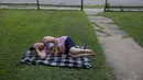 Dawn Borchert tidur di halaman depan rumahnya di sebuah lingkungan dekat 11th Street dan Lewis Ave, di Tulsa, Oklahoma, Selasa (20/6/2023). Borchert tidak memiliki listrik sejak badai akhir pekan dan tidur di tenda semalaman, tetapi pindah ke luar untuk menyejukkan diri pada pagi hari. (Mike Simons/Tulsa World via AP)