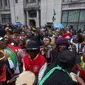 Warga Zimbabwe yang menetap di Inggris menggelar aksi protes di luar Kedutaan Besar Zimbabwe di London, Sabtu (18/11). Tak hanya menggelar long march, mereka juga menari dan minum bersama sambil menyerukan teriakan agar Mugabe mundur. (NIKLAS HALLE'N/AFP)