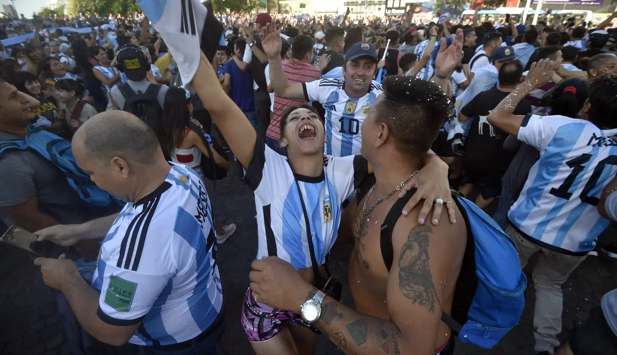 Para penggemar Argentina merayakan kemenangan atas Kroasia pada akhir pertandingan semifinal Piala Dunia  2022 Qatar setelah menontonnya di layar, di mana gambar langsung Lionel Messi ditampilkan, di lingkungan Palermo di Buenos Aires, Argentina, Rabu (14/12/2022). (AP Photo/Gustavo Garello)