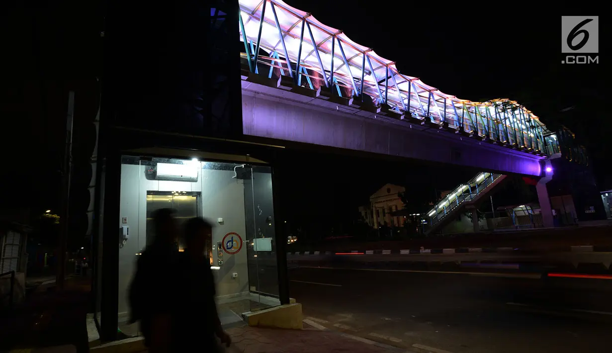 Lampu yang bisa berganti-ganti warna menghiasi jembatan penyeberangan orang (JPO) di kawasan Jakarta Timur, Kamis (27/12). Di malam hari, JPO tersebut lampu warna-warni menyala terang sehingga terlihat cantik dari kejauhan. (Merdeka.com/Imam Buhori)