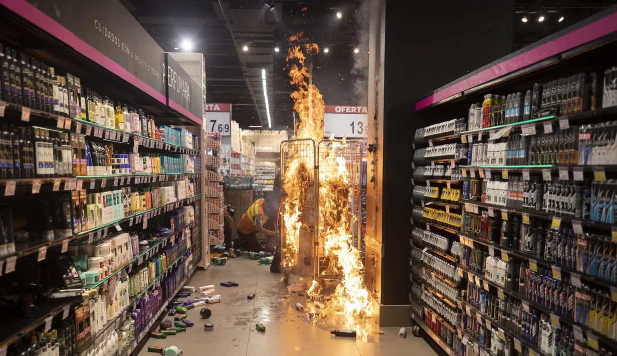 Api yang dibuat oleh pengunjuk rasa membakar di dalam supermarket Carrefour selama protes terhadap pembunuhan pria kulit hitam Joao Alberto Silveira Freitas di supermarket Carrefour yang berbeda pada malam sebelumnya, pada Hari Kesadaran Kulit Hitam Nasional Brasil di Sao Paulo, Brasil (20/11/2020).