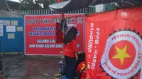 Buruh perempuan berdiri di depan tenda protes di depan gerbang PT Sokolancar/Bapintri, Kota Cimahi, Jawa Barat, Kamis, 28 Maret 2024. (Dikdik Ripaldi/Liputan6.com)