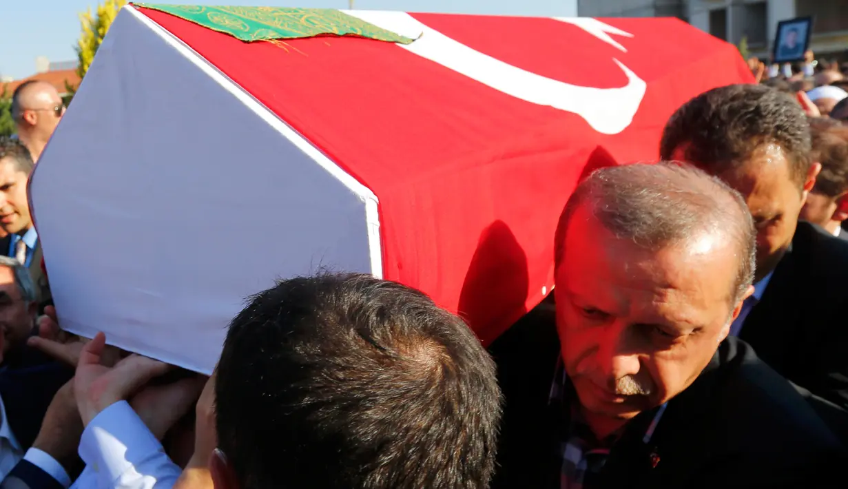 Presiden Turki, Recep Tayyip Erdogan ikut membawa peti jenazah korban upaya kudeta militer yang dilakukan terhadapnya, di Istanbul, Minggu (17/7). Perlawanan terhadap kudeta militer Turki pada Jumat kemarin menewaskan 265 orang. (REUTERS/Murad Sezer)