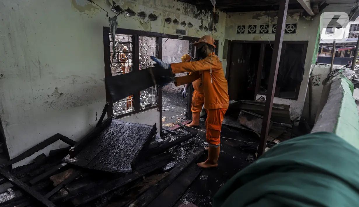 Petugas membersihkan sisa kebakaran di permukiman padat Kelurahan Bali Mester, Jatinegara, Jakarta, Selasa (8/9/2020). Kebakaran di permukiman padat itu melalap 11 rumah tinggal warga serta satu unit bengkel dan mengakibatkan 60 orang mengungsi. (Liputan6.com/Johan Tallo)